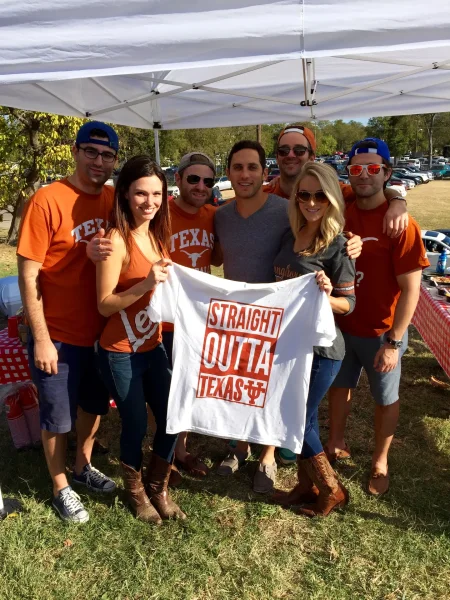 Texas vs OU - Longhorns fans holding a Straight Outta Texas shirt under the tent - Dallas VIP