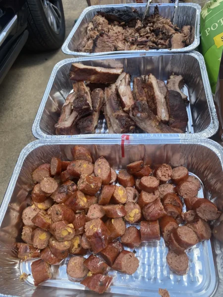 Corporate Tailgate - Trays of chopped brisket, pork ribs and jalapeno cheddar sausage at the tailgate - DallasVIP