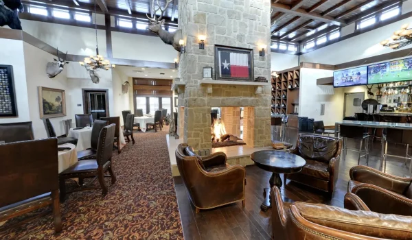 Frisco Gun Club - Stone fireplace, mounted trophies and a Texas flag in the clubhouse dining room - DallasVIP
