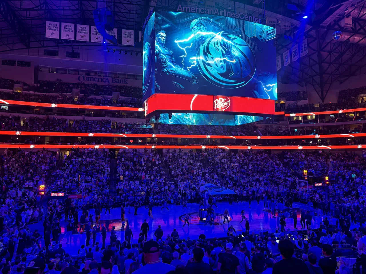 Lights down for Mavericks player intros under the American Airlines Center videoboard, with the suite level ringing the bowl